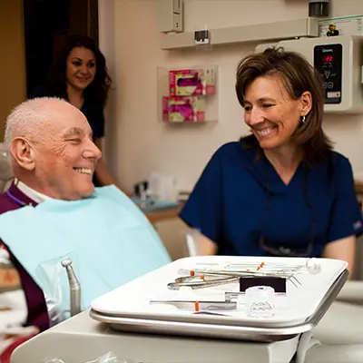 Dr. Joy Arend talking to a patient while the dental assistant enters the operatory at East Portland Dentistry 