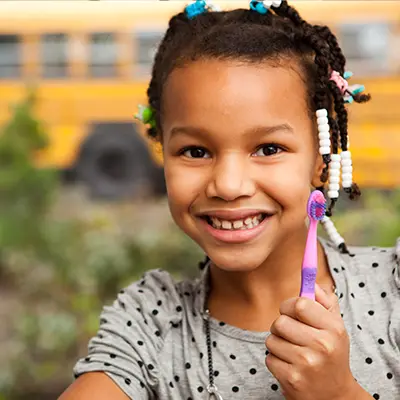 A kid holding a tooth brush at East Portland Dentistry.