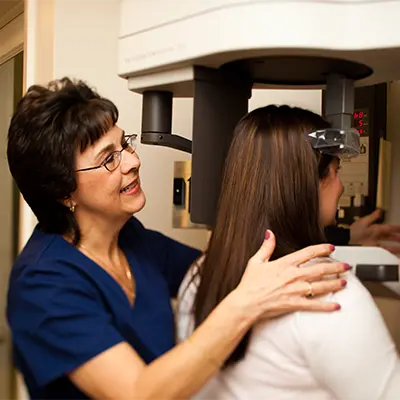 A dental assistant taking a 3d scan of a patient in the 3d cone beam scanner