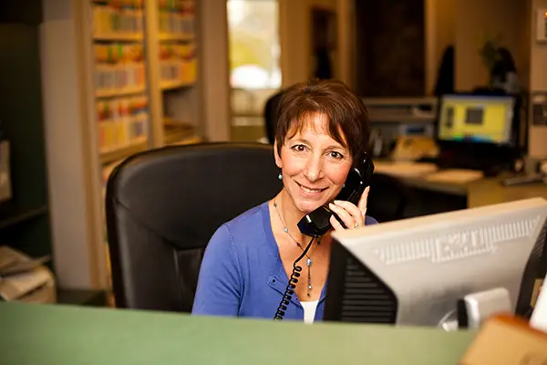 A receptionist on the call helping patient at East Portland Dentistry.