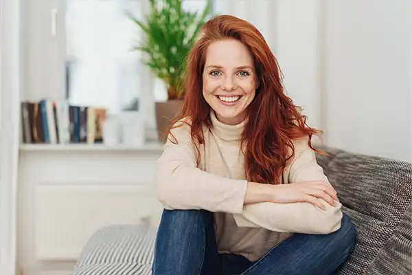 A woman on sofa smiling.