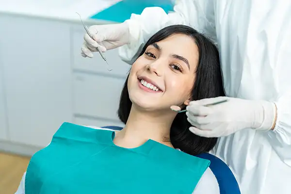 AdobeStock 417516266 Smiling dental patient sitting in dental chair