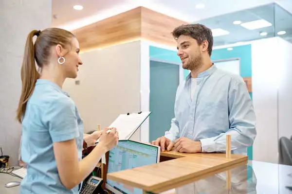 A receptionist helping a patient checkin