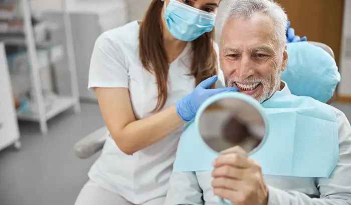 A patient and hygienist looking at patient's smile in mirror at East Portland Dentistry