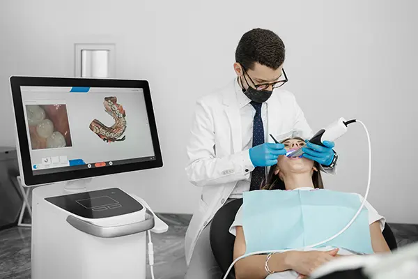 Patient relaxing while her dentist uses an intra-oral scanner to take a digital impression.