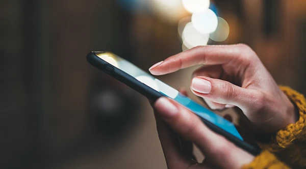 Close up of slender hands scrolling through a smart phone