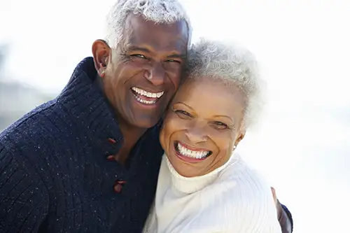 An old couple hugging and smiling.